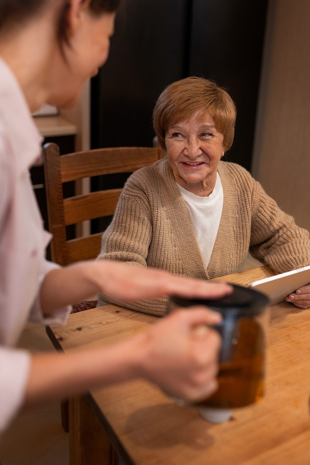 Younger woman pours older woman coffee